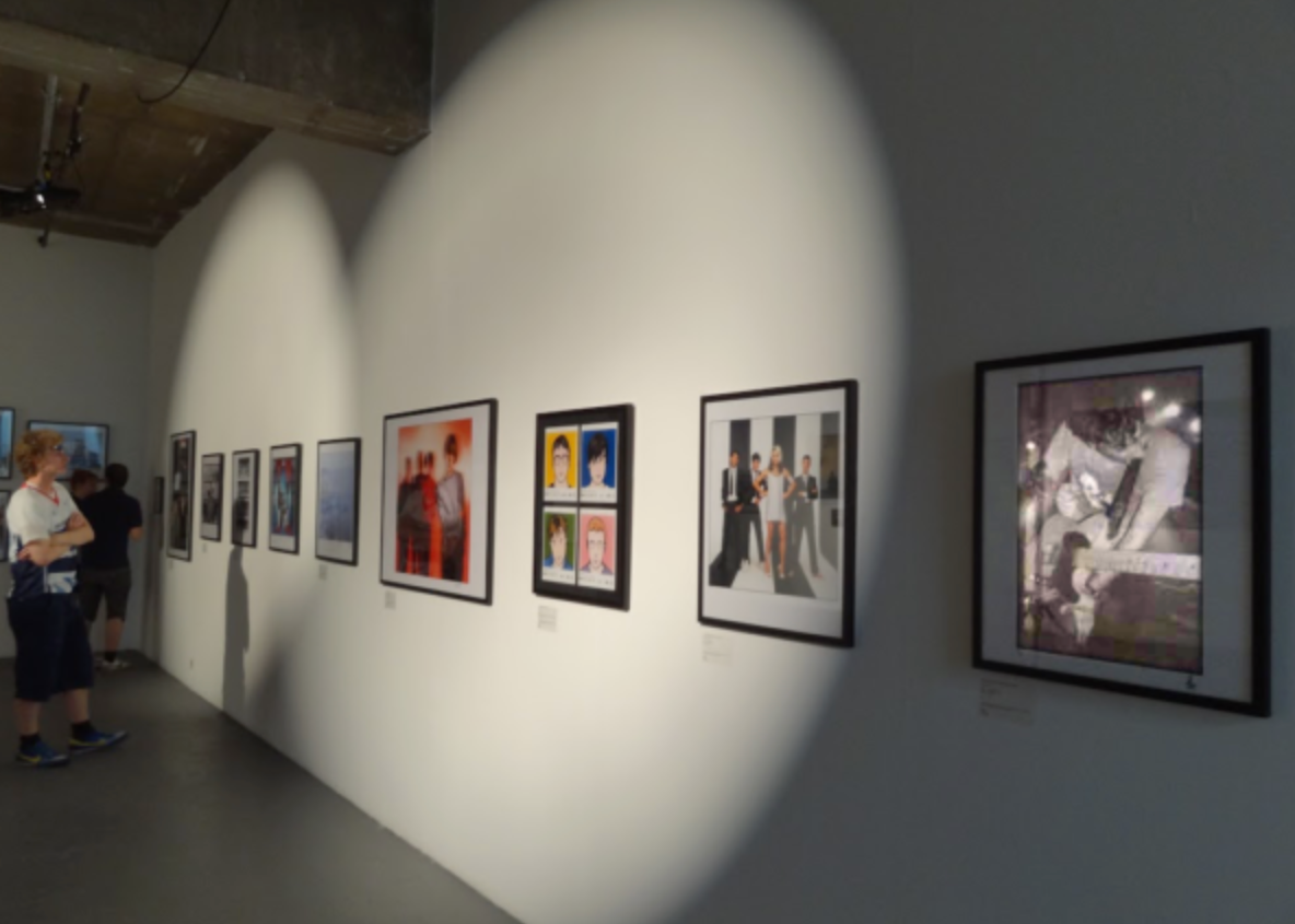 Pictured is a wall of framed graphic designs of the band as well as portraits.