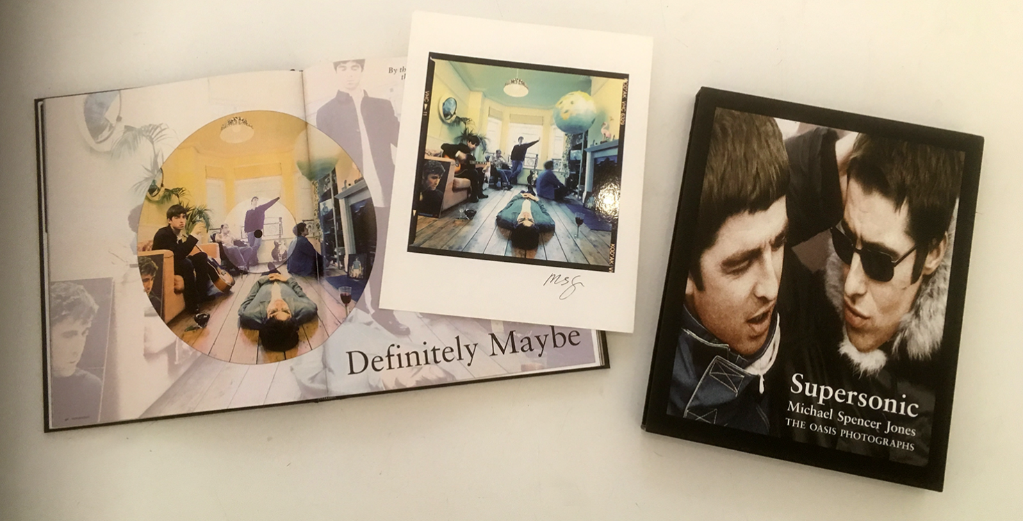 Pictured is the book, "Supersonic, The Oasis Photographs" by Michael Spencer Jones, as well as a signed 'Definitely Maybe' album cover print (middle).