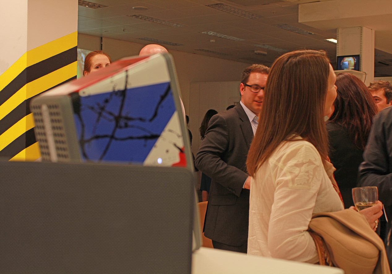 A photo from the exhibition showing multiple attendees conversing around a Sonos speaker playing The Stone Roses