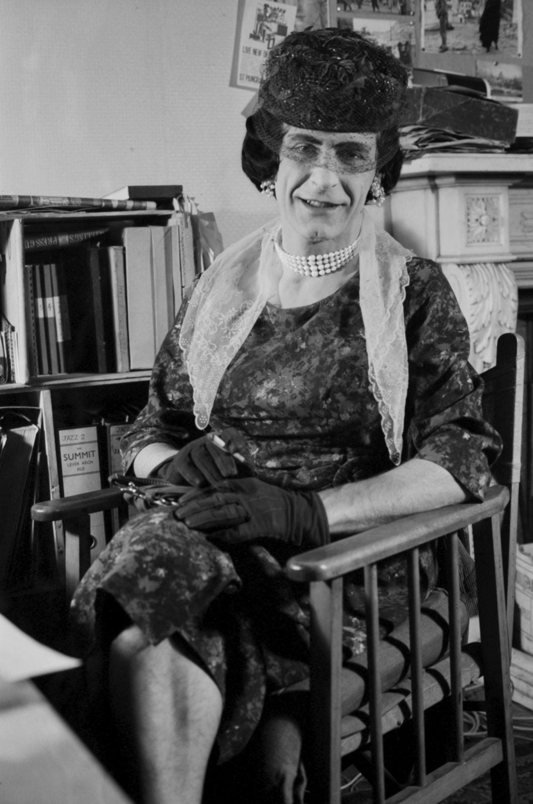 A beautiful lady sitting elegantly with her legs folded and her hands on her knee in a wooden chair